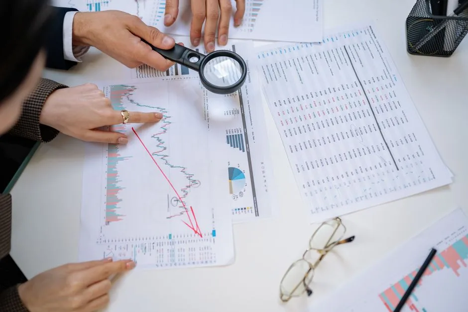 Analista financiero revisando registros contables y transaccionales para validar EBITDA y capital circulante en una adquisición empresarial